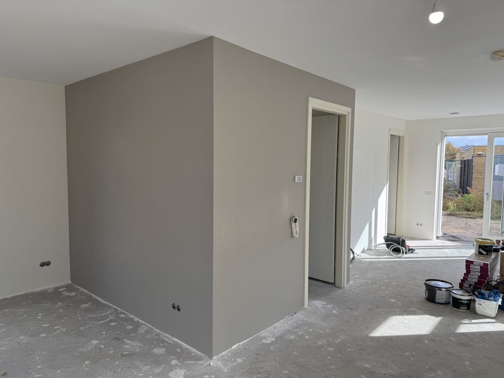 Gesausde wanden in een nieuwbouwwoning, glad afgewerkt rond een deur naar de gang